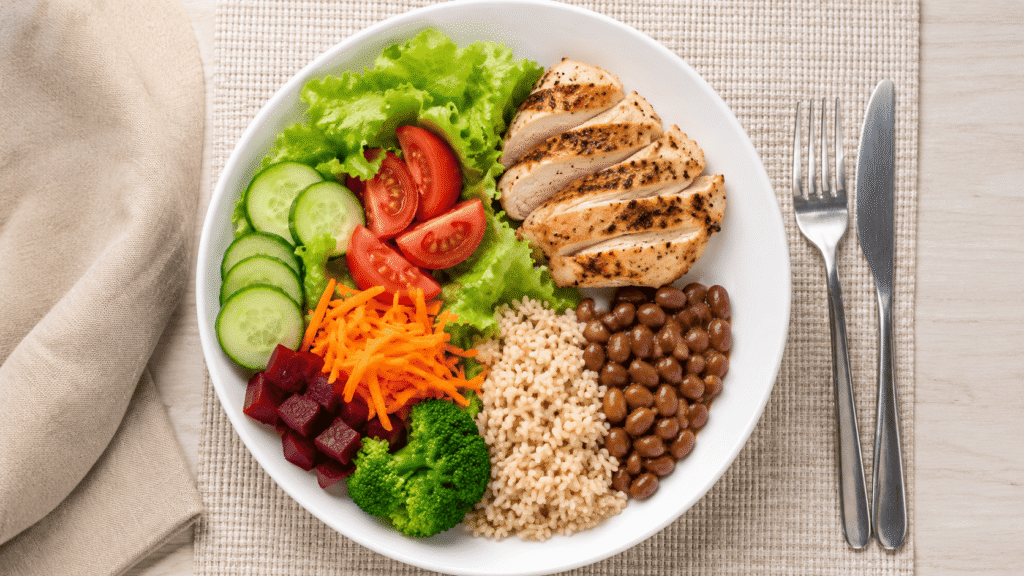 Prato equilibrado com vegetais, arroz, feijão e proteína magra.